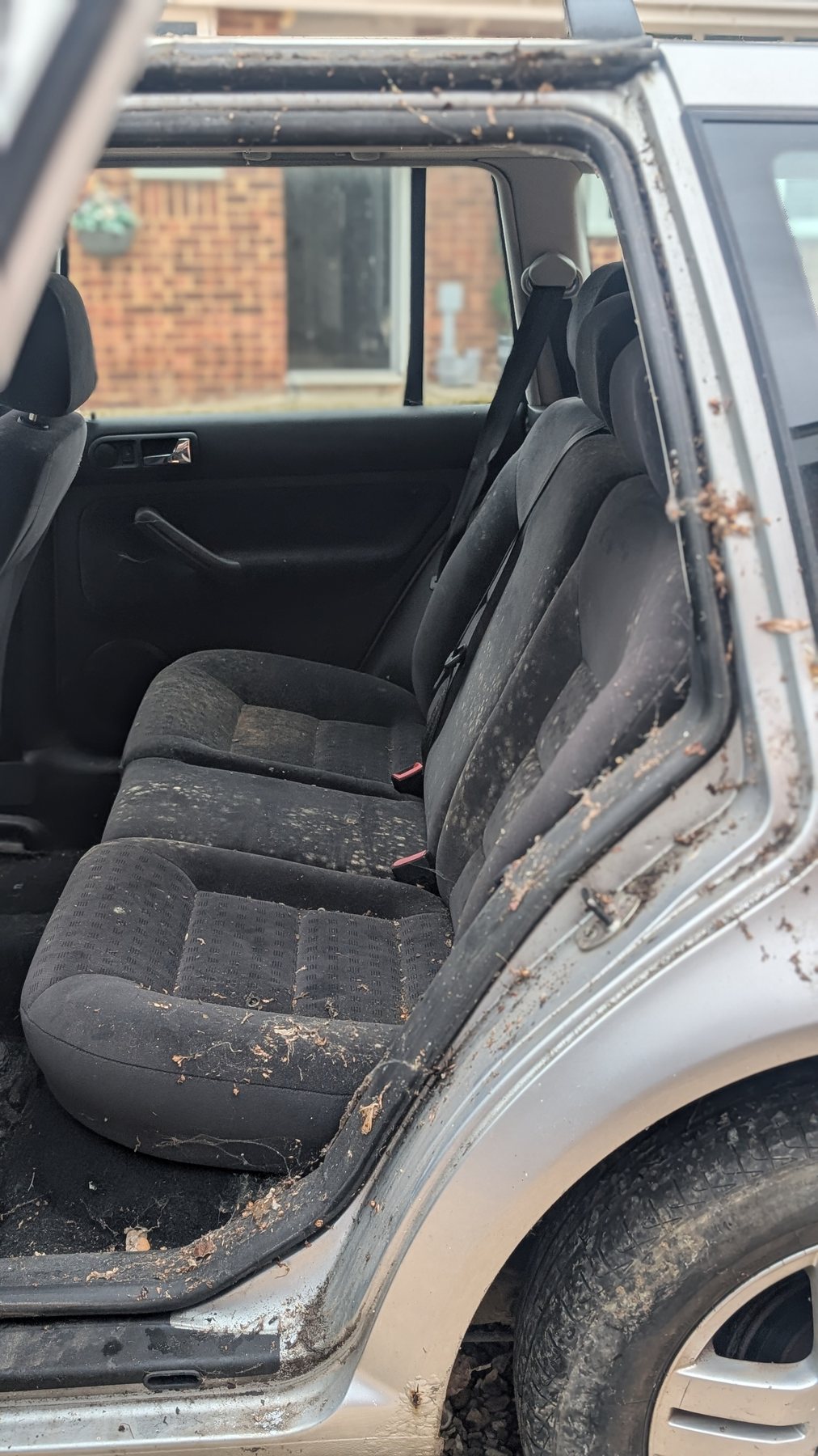 Rear seats before extraction — covered in debris